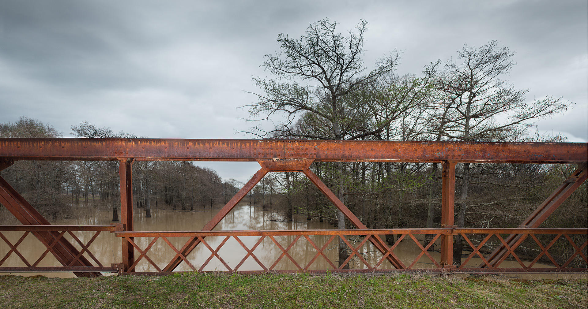 <div class="storycaption">
	<div class="galleryIntroTextArea holder">
		<div class="galleryIntroTextContent">
			<div class="galleryIntroTextContentInside">
				<div class="frishhead">
					BLACK BAYOU BRIDGE 
				</div>
				<div class="frishsubhead">
					GLENDORA, MISSISSIPPI 
				</div>
				<div class="frishtext">
					In 1955, when Emmett Till was fourteen, his mother put him on a train from Chicago to spend the summer visiting his cousins in Money, Mississippi. She never saw him alive again. Her son was abducted and brutally murdered on August 28, 1955, after being falsely accused of interacting inappropriately with a white woman. His body was dumped into the muddy waters below Black Bayou bridge. The following month, Roy Bryant and his half-brother J.W. Milam faced trial for Till's kidnapping and murder but were acquitted by the all-white jury after a five-day trial and a 67-minute deliberation. One juror said, "If we hadn't stopped to drink pop, it wouldn't have taken that long." Only months later, in an interview with Look magazine in 1956, protected against double jeopardy, Bryant and Milam admitted to killing Emmett Till. In 2017 the alleged victim, Carolyn Bryant, admitted that Emmett was innocent. 
				</div>
				<div class="frishdate">
					PHOTOGRAPHED: 2019 
				</div>
			</div>
		</div>
	</div>
</div> : IMAGES : Ghosts of Segregation